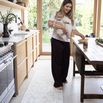 Woman holding a baby on a padded foam standing man 