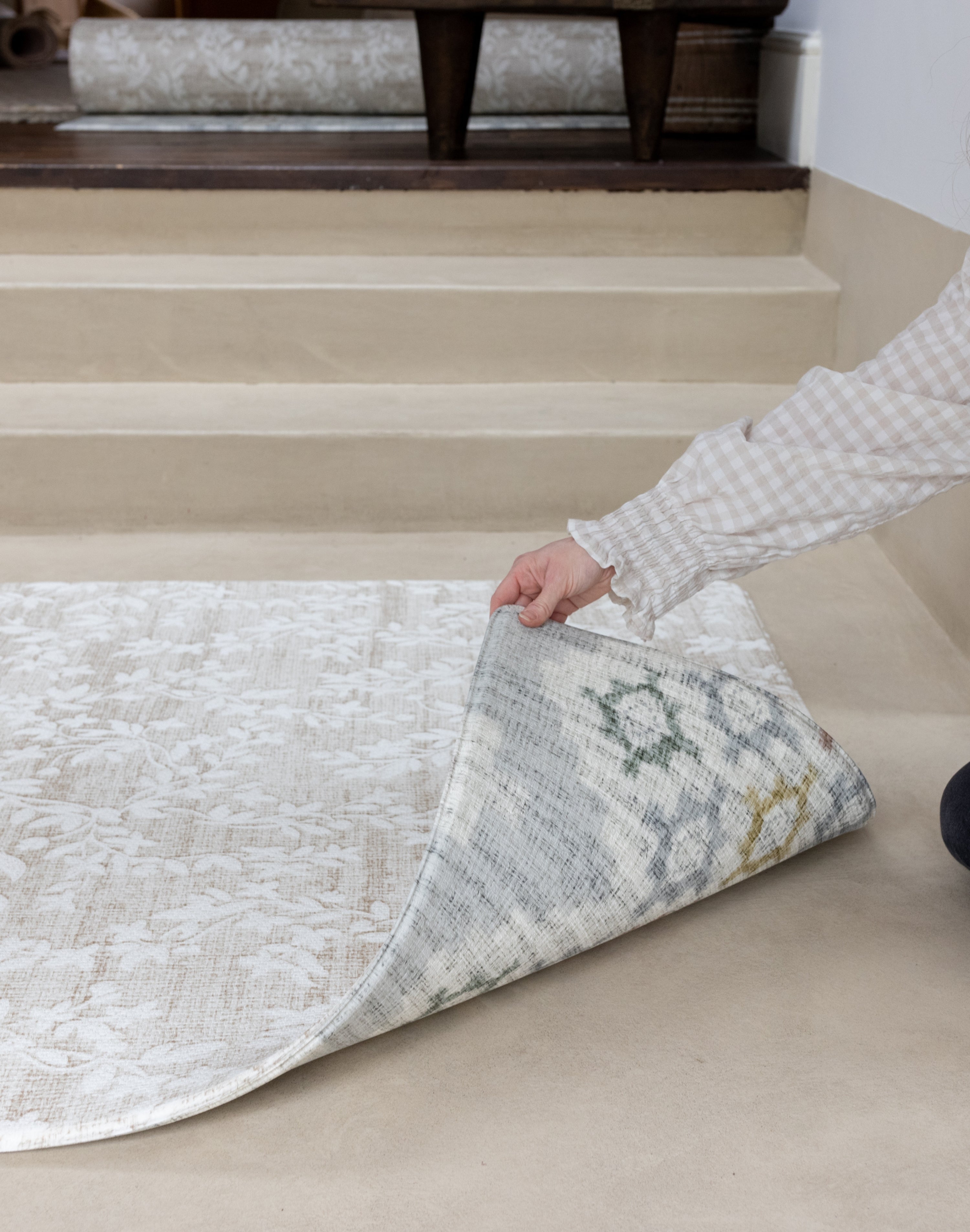 Person rolling out a reversible baby play mat for hardwood floors