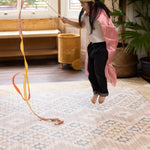 Child jumping on a 1.3cm thick cushioned memoru foam luxury double sided play mat