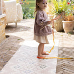 Child playing with a bubble wand on a premium foam outdoor mat 