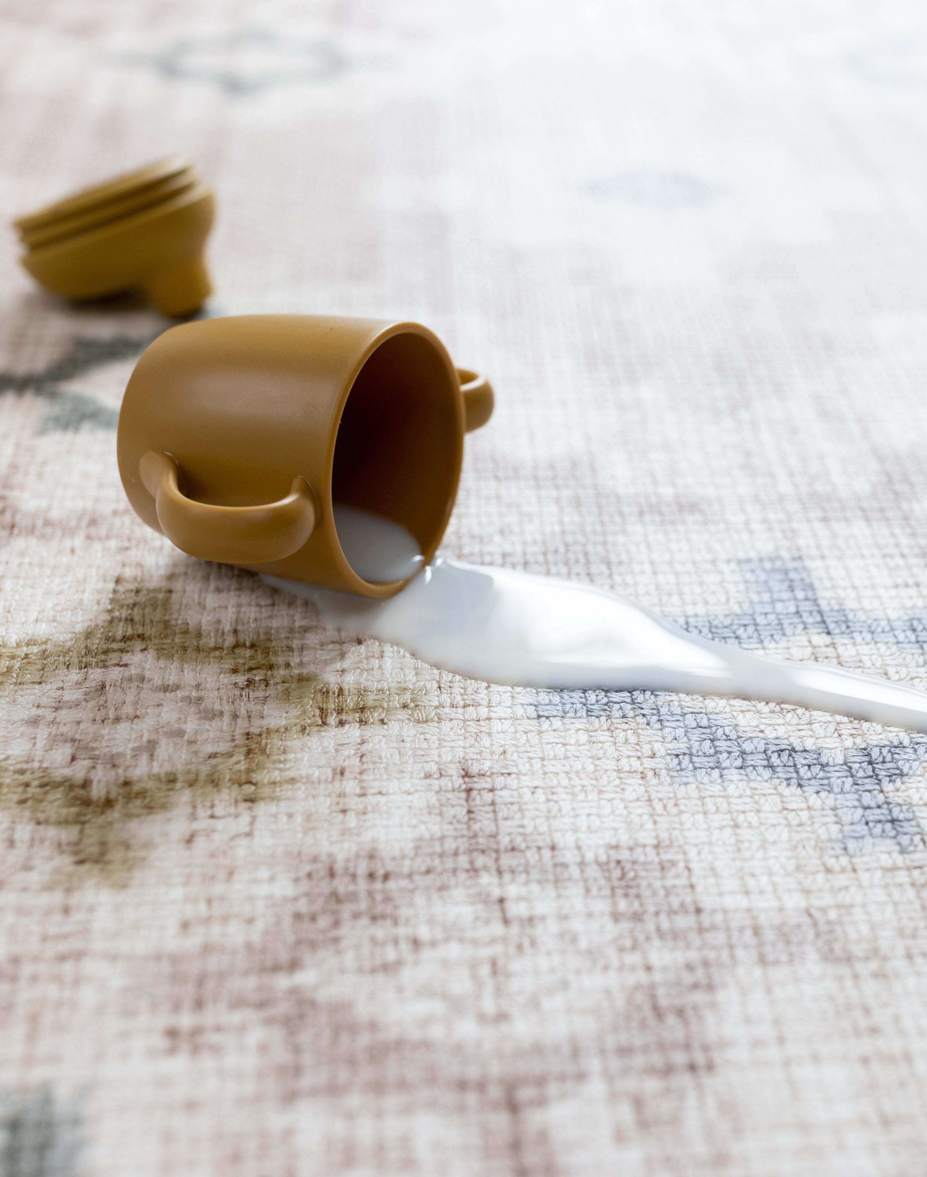 cup fallen over on a spill proof baby play mat for nursery floor
alfombra de actividades para bebé
