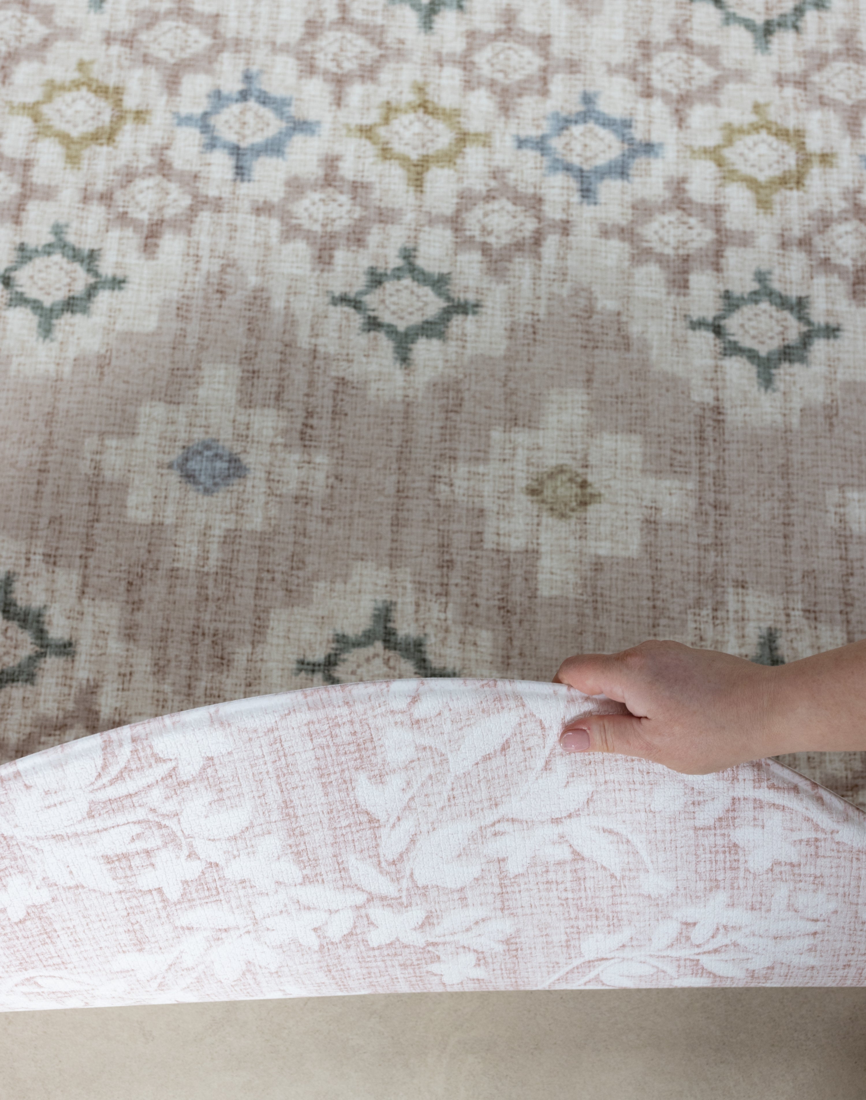 person showing both sides of a pink luxury reversible play mat