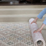 Person unrolling a double sided baby play mat on a hard ceramic floor 
stilvolle Baby Spielmatte für das Wohnzimmer