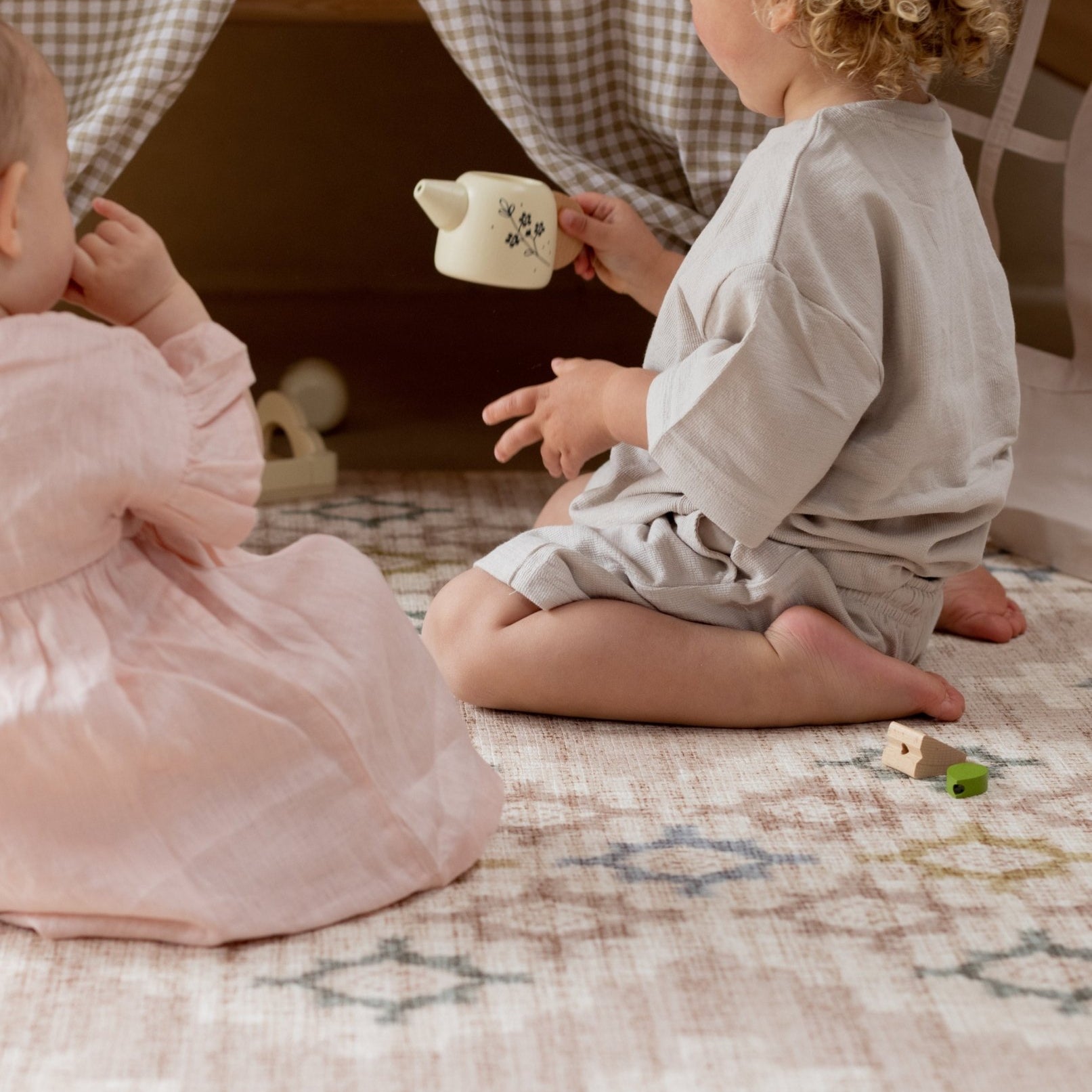 Two children playing with a tea cup on a reversible baby play mat with elegant design | SKU: 26 FABLE/ASTER STD,26 FABLE/ASTER XL,26 FABLE/ASTER COM,26 FABLE/ASTER ROU,26 FABLE/ASTER RUN