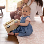 Child playing with a toy on a cushioned mat for practicing sitting up safely