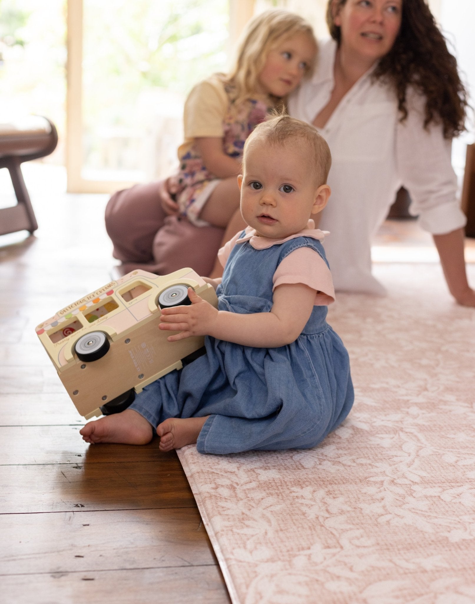 Child playing with a toy on a cushioned mat for practicing sitting up safely