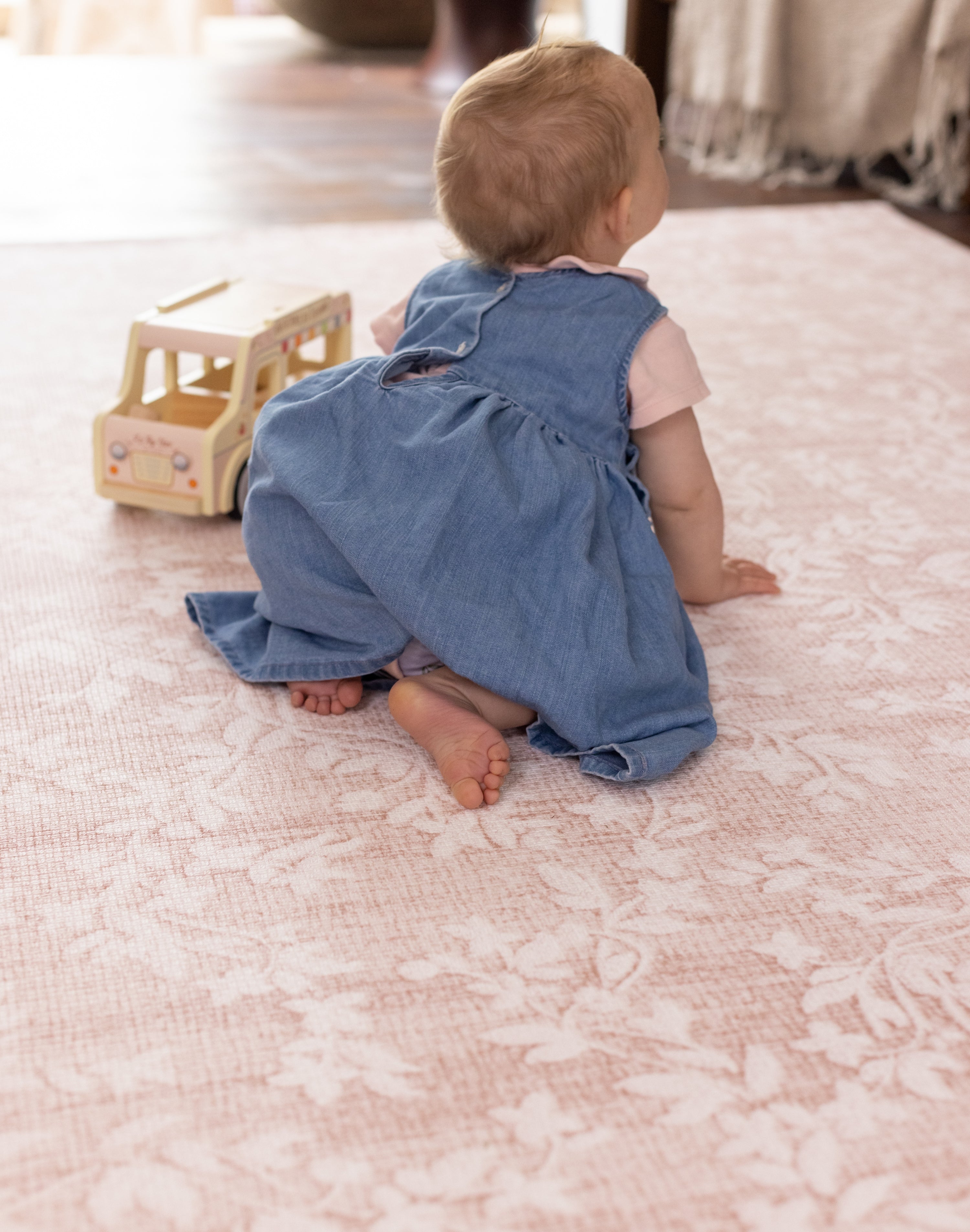 Child playing on a pink flower designer baby play mat safe for crawling 
alfombra infantil premium