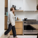Woman walking on an easy cleaning padded standing kitchen runner mat 