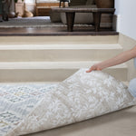 Person rolling out a play mat that complement home decor on a hard floor