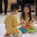 Two children eating food on an easy clean spill proof closed cell wipable rug