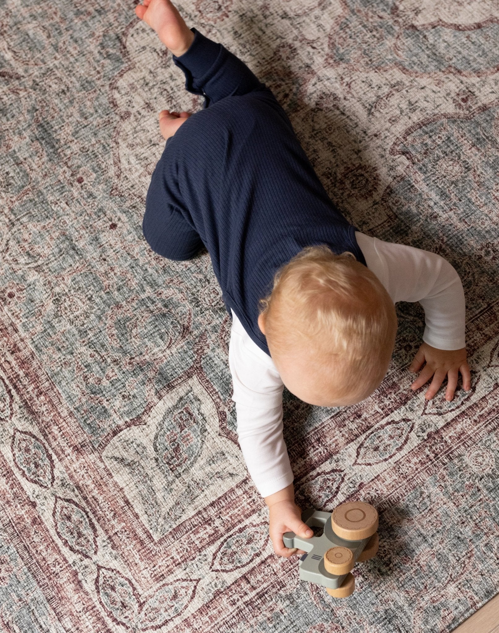 Young child playing on Totter + Tumble soft washable playmat.