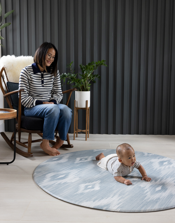 Mother watches baby on round Padded baby play mat that the whole family will love The Atlas is available in four sizes so you can choose the perfect size for your family space