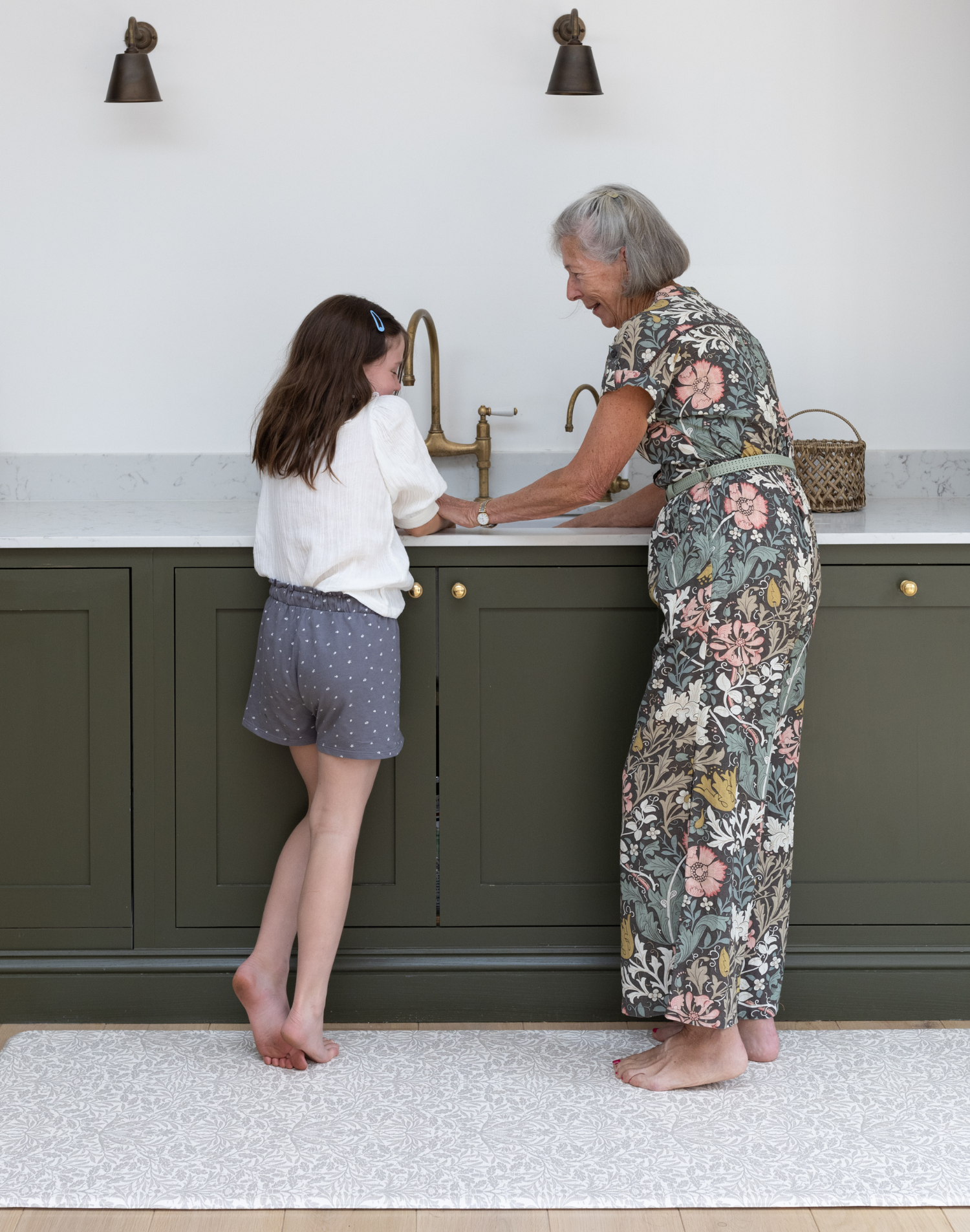 the acorn play runner in family kitchen with grandmother and child at the sink standing mat that is wipedown and easy to clean - great for the whole family to enjoy playtime together looks like a rug but actually thick padded play mat
