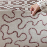 Close-up of the Brecon round baby playmat's tufted texture + abstract pattern, a nature-inspired playmat with heritage design