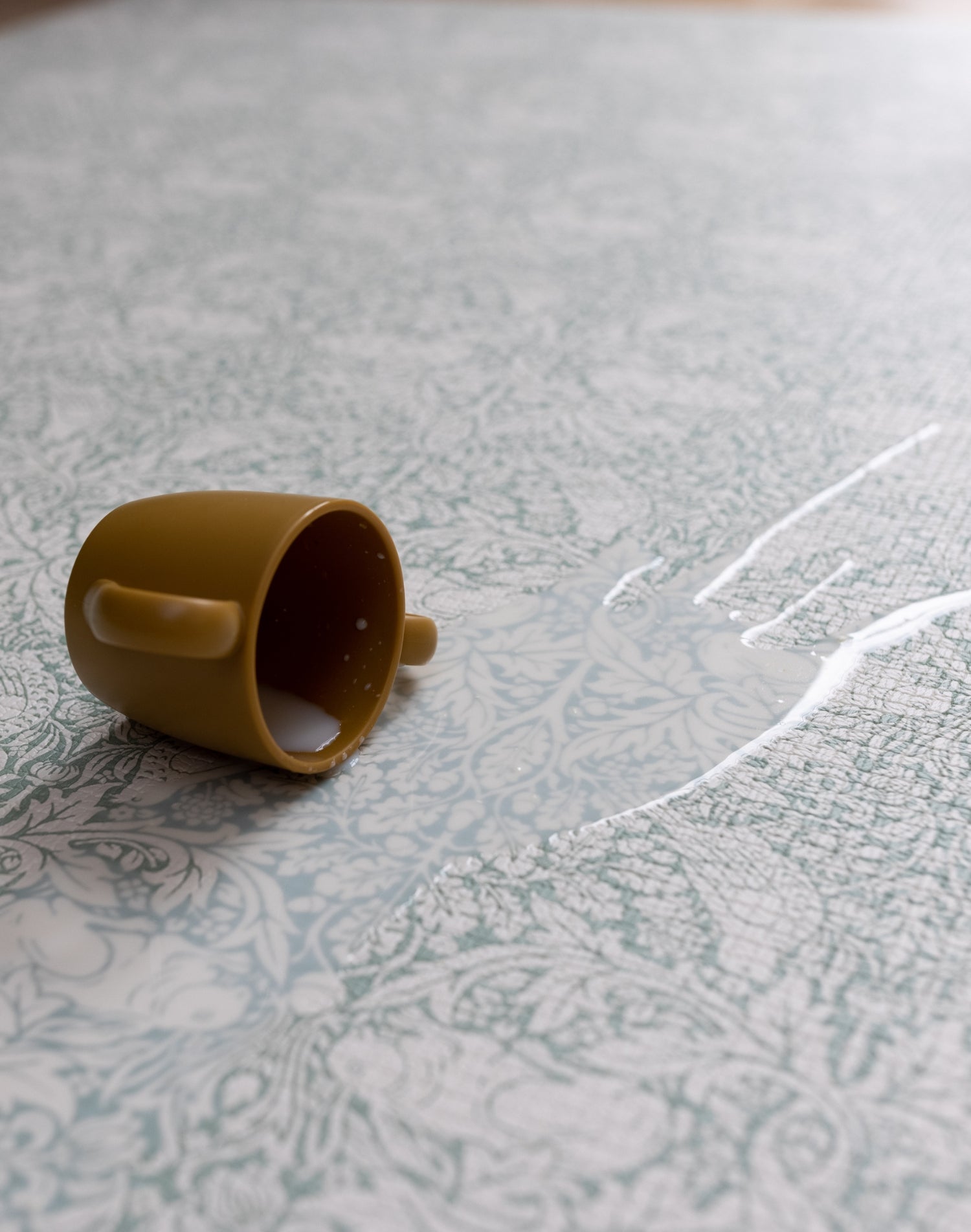 Detail of The Brer Rabbit Playmat’s botanical pattern being wiped clean- a practical yet stylish non-toxic play mat with easy-care surface.