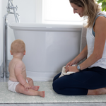totter and tumble play runner beside the bath with mom and baby staying warm as play mat insulates from cold floor, non slip and comfortable great for bathroom
