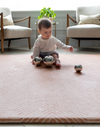 Little girl plays with sensory toys on the Totter and Tumble Tapis designed for safe play in the home 