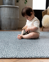 Baby enjoys playtime with wooden toy on extra large play mats