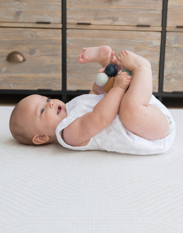 XSmiley baby laying comfortably on thick Kilim play rug designed for babies, adults and stylish family homes 