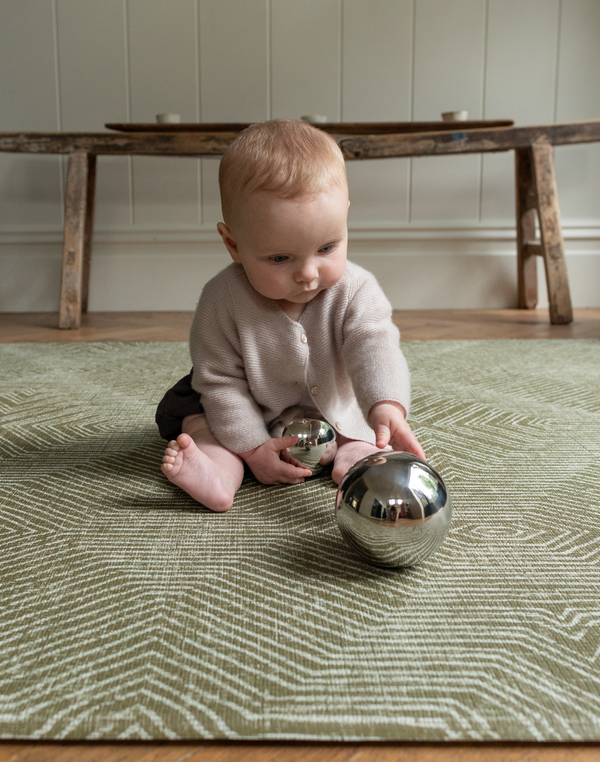Cute baby enjoying sensory play on thick floor mat ideal for play time 