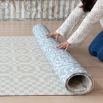 Rolling up The Pembroke, a compact, wipeable baby play mat with a coastal-inspired playmat pattern for modern homes.