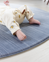 Close up of babies feet on The Kasuri a large padded floor mat by Totter and Tumble adds a stylish appeal to the space it is unrolled in with a one piece design that is washable so spillages are easy to clean the perfect play rug for the home