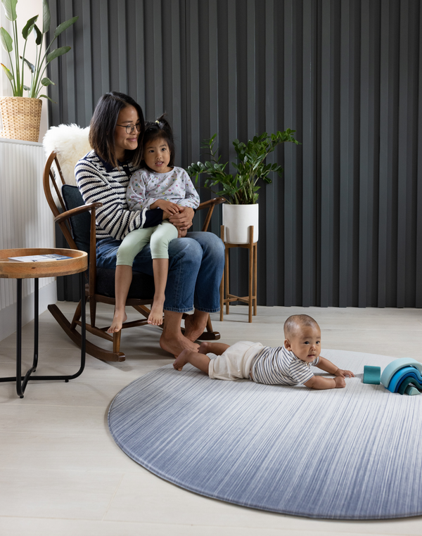 Mother and two children on Large round play mat for modern family homes The Kasuri is stylish with a gradient designs he navy blue play mat is perfect for anywhere in the home
