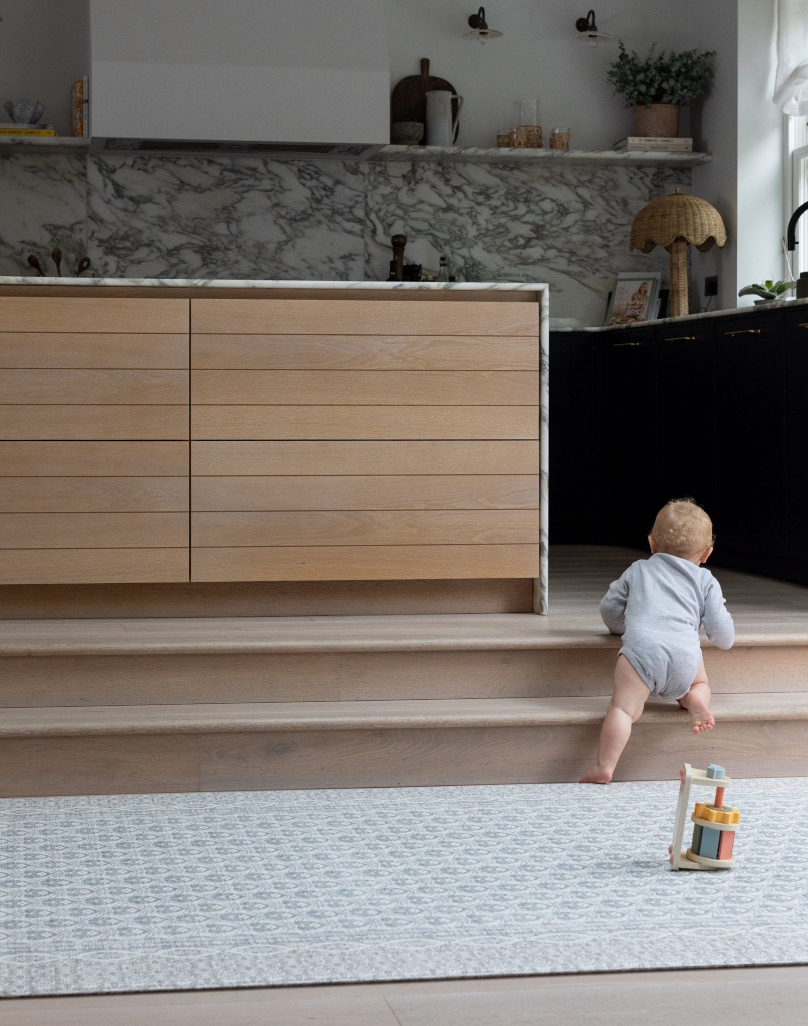Toddler walking across large soft baby mat in neutral living space