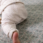 Crawling baby on a thick memory foam playmat from Totter + Tumble