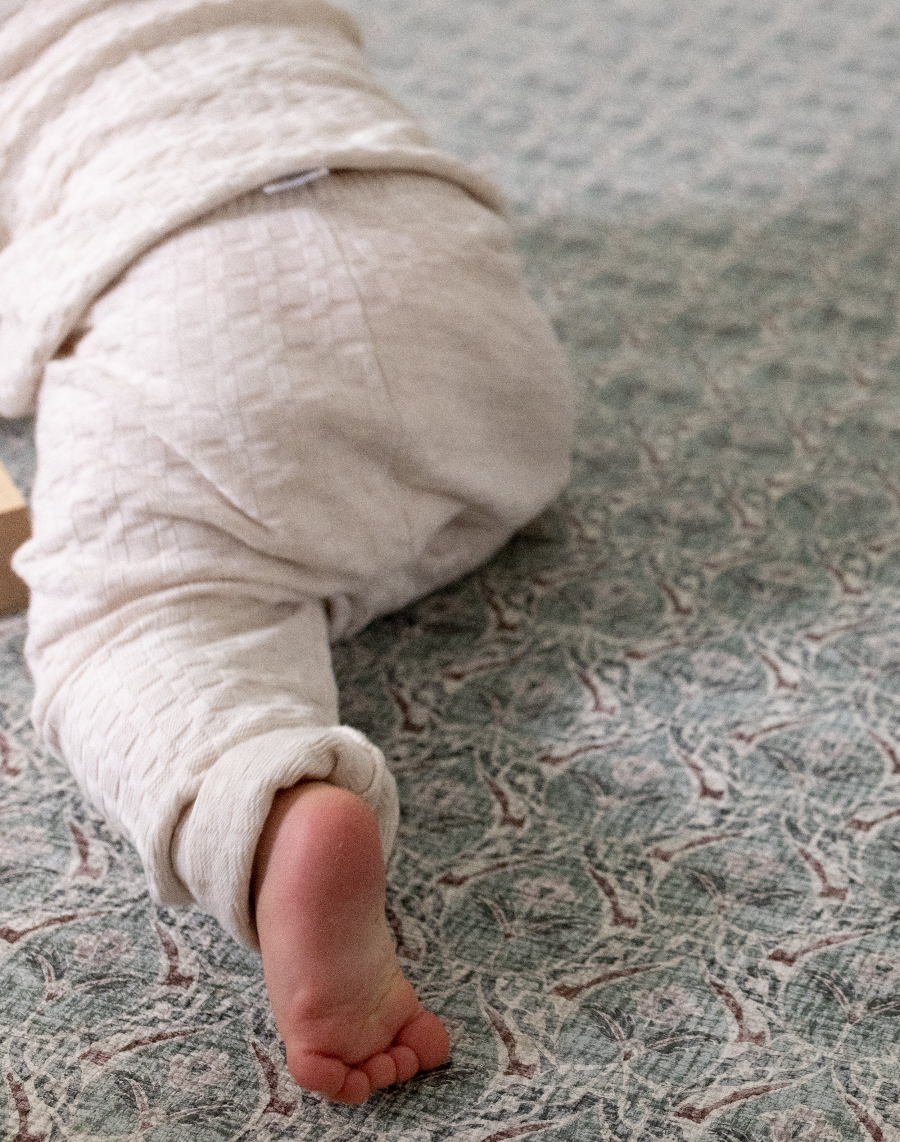 Crawling baby on a thick memory foam playmat from Totter + Tumble