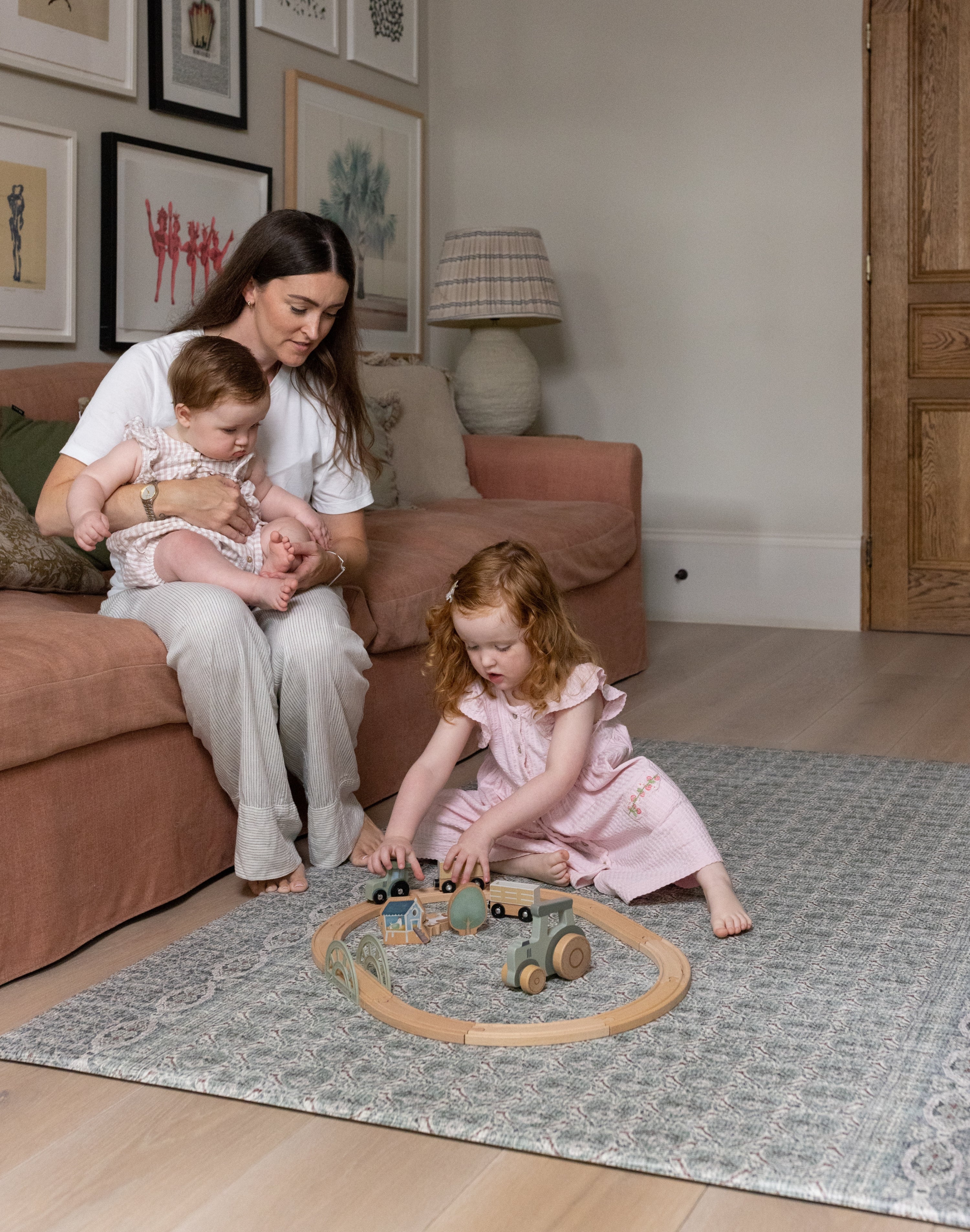 Family sitting together and playing on Totter + Tumble soft spruce playmat in a stylish living room