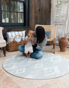 Mother and baby enjoying floor time on Large round tumble mat by Totter and Tumble with modern ikat design to look like a rug in your home