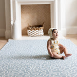 Baby sits on The Pembroke, a calming sea foam blue rug, perfect as a large play mat for crawling baby.