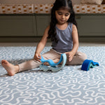 Girl playing on The Pembroke, a large playmat for toddlers in a coastal-inspired colour palette with heritage design.