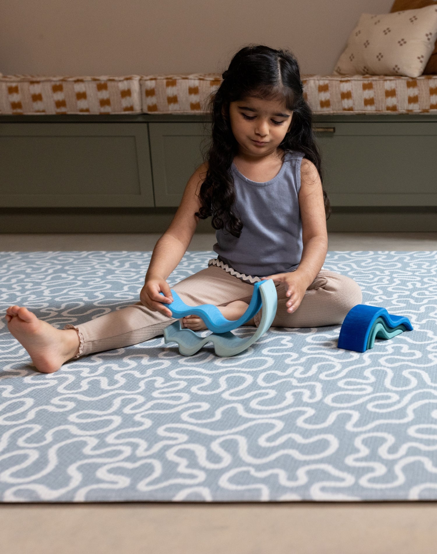 Girl playing on The Pembroke, a large playmat for toddlers in a coastal-inspired colour palette with heritage design.