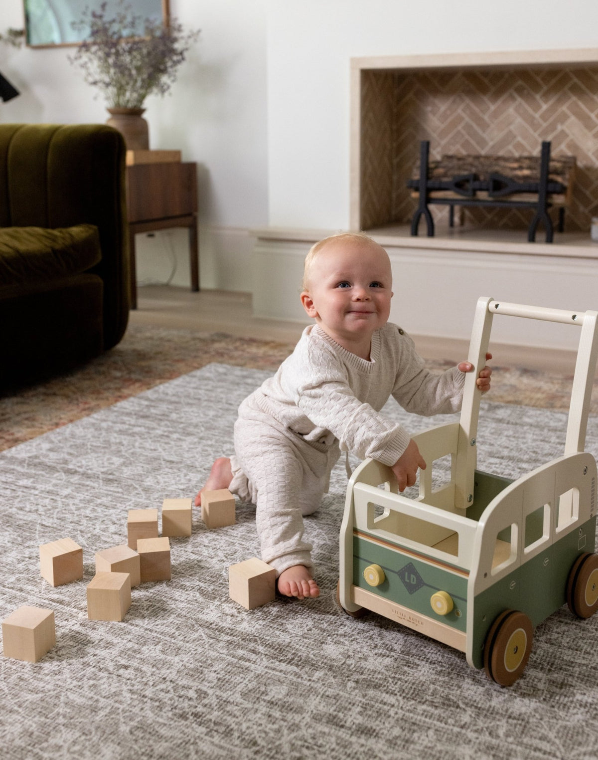 Baby playing with a wooden cart on a play mat for open plan living