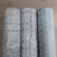 Rolled grey and neutral textured play mats that are rug like
