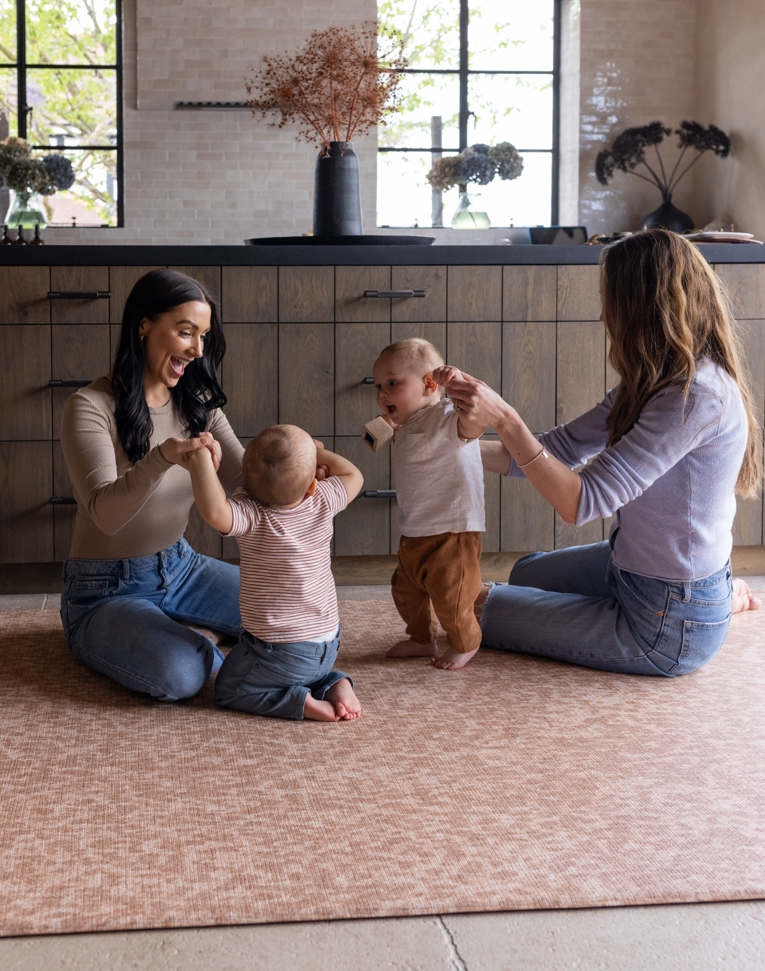 Mums and babies play on large crawling play mat padded to support and protect on the tiled flooring while complementing the modern interior
