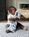 Baby enjoys play time on supportive groot speelmatten with black ad white design 