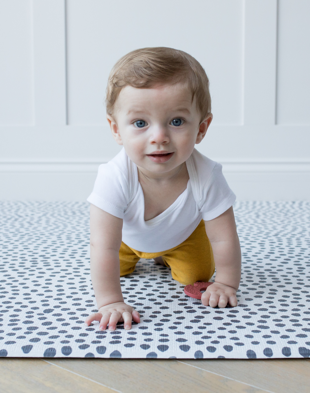 Little baby crawls across crawling mat with textured surface for traction while moving 