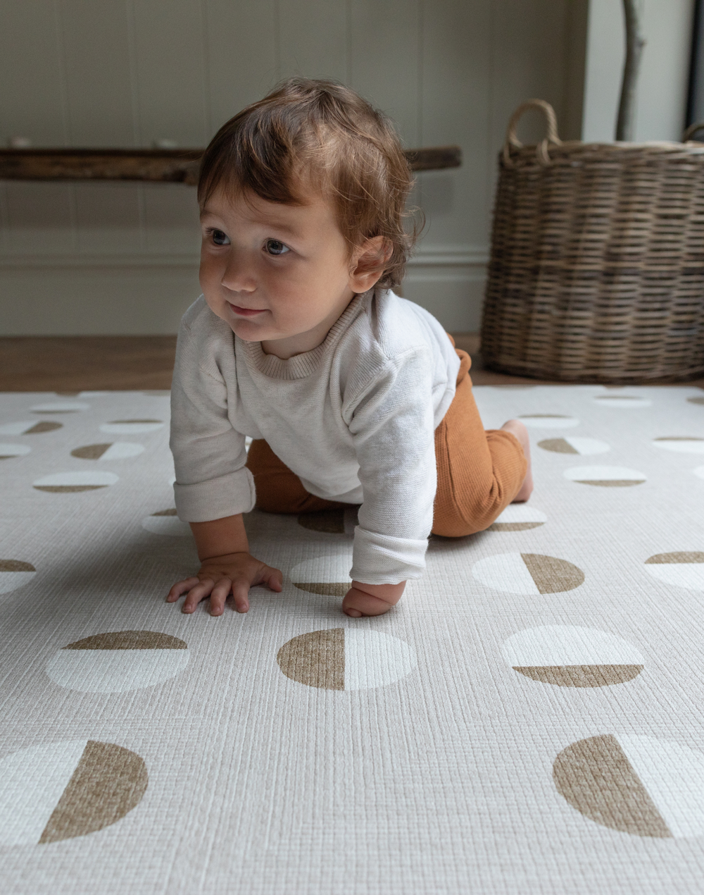 Baby is supported on thick Spelmatta with durable memory foam and organic polka design 