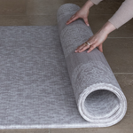 Hands roll out the reversible grey play mat by totter and tumble with two complementary grey designs for family homes and thick memory foam for comfy floor time activities