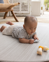 Baby enjoying tummy time on Large round tumble mat by Totter and Tumble with modern gradient design to look like a rug in your home