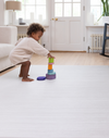 Baby stacking up wooden blocks on Baby play mats the whole family will love The Tali has a stylish ombre design with tan and beige tones