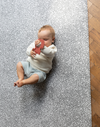 Baby plays on soft foam mat with textured teething toy 