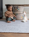 Little boy plays with soft toy on thickly padded playmat ideal for playtime