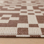 Close up of a 1.3cm thick crawling mat for newborns+. The playmat features a Portcullis motif in roasted umber + birch.