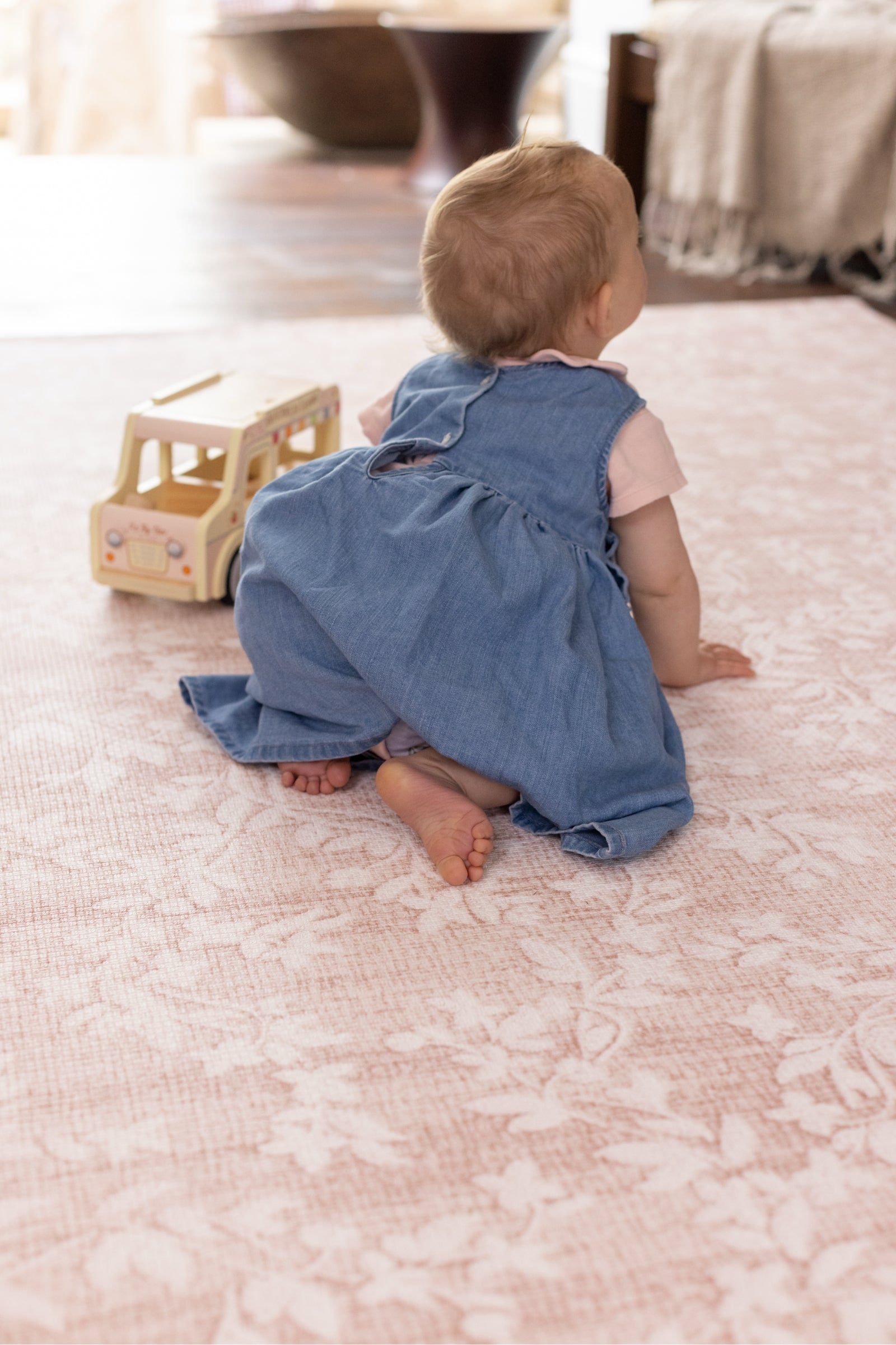 Baby crawling on a pink floral aster playmat from totter and tumble