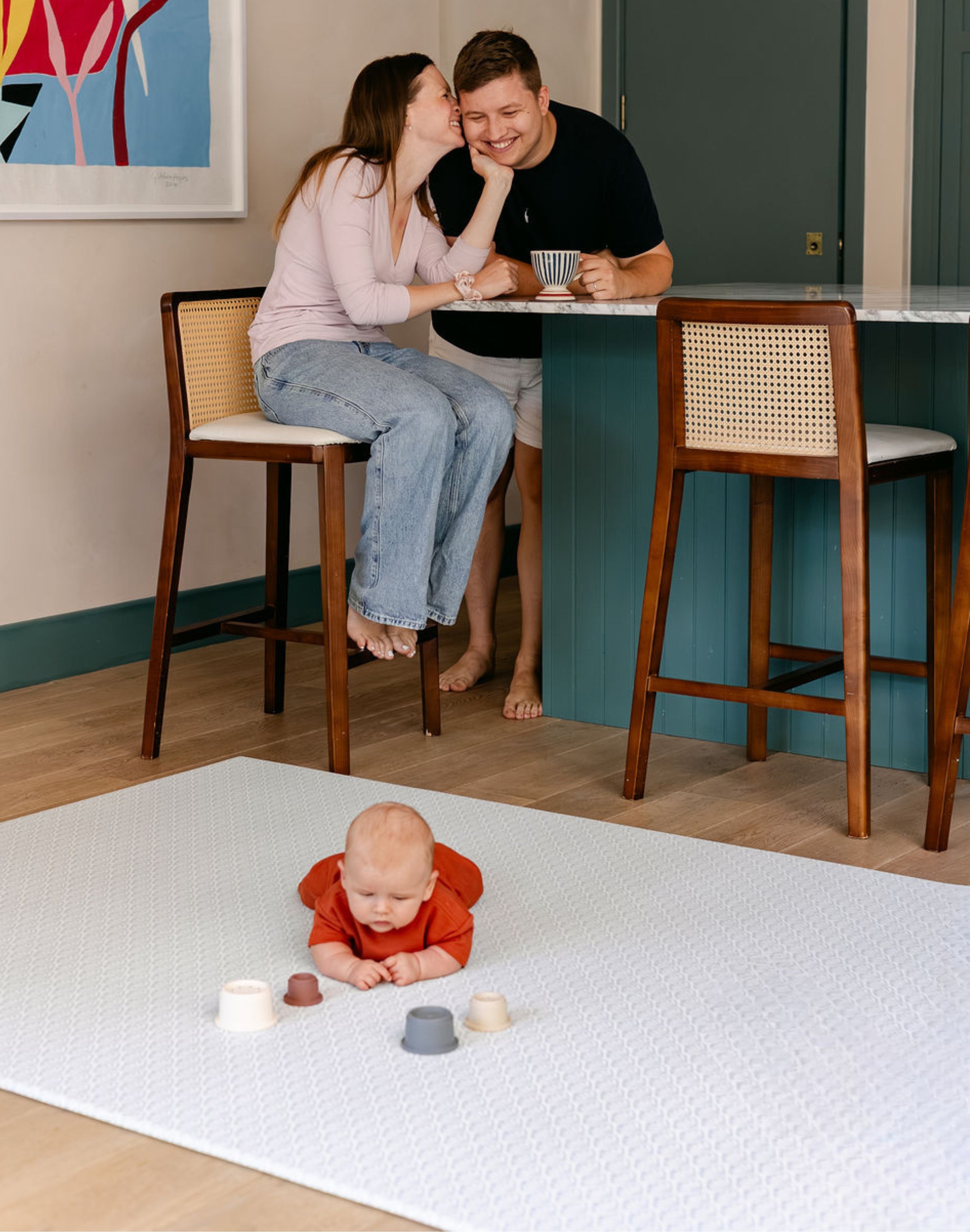 A baby enjoying tummy time in the kitchen on the beachcomber totter and tumble playmat