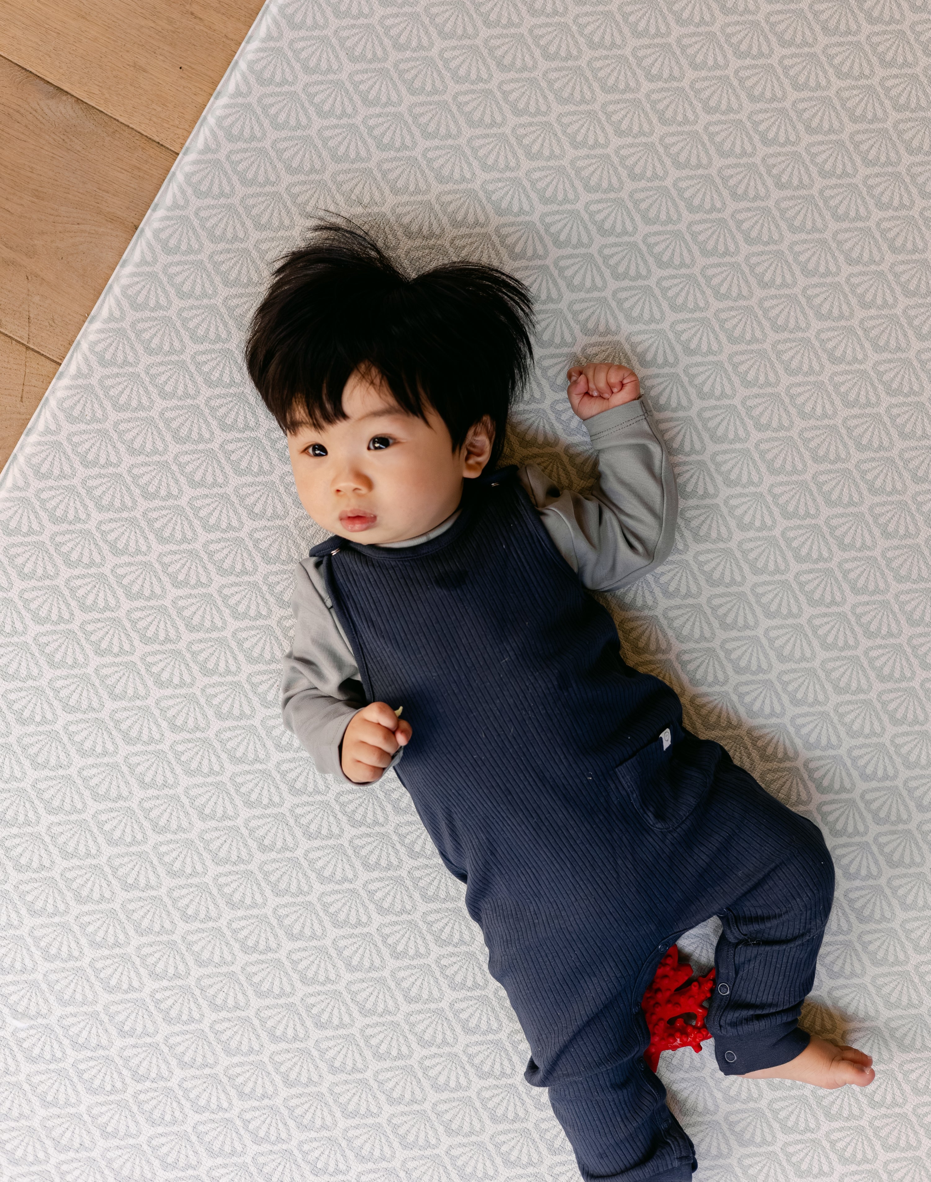 Baby laying down on a thick comfortable memory foam blue shell design beachcomber playmat | SKU: 26 BEACH/GATHER XL, 26 BEACH/GATHER STD, 26 BEACH/GATHER COMP